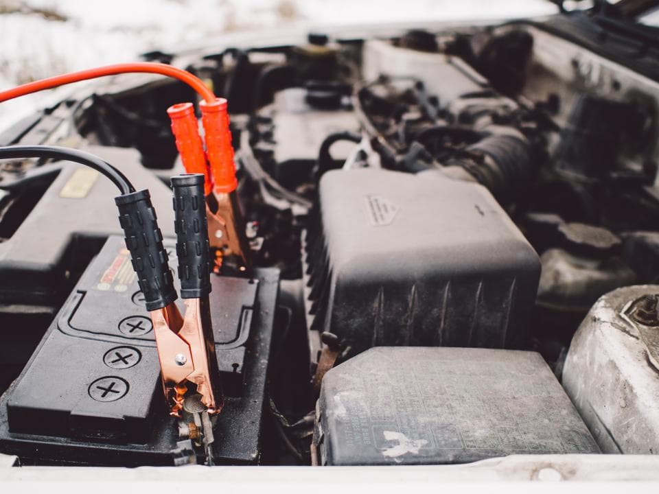 A car engine bay during a battery jump start