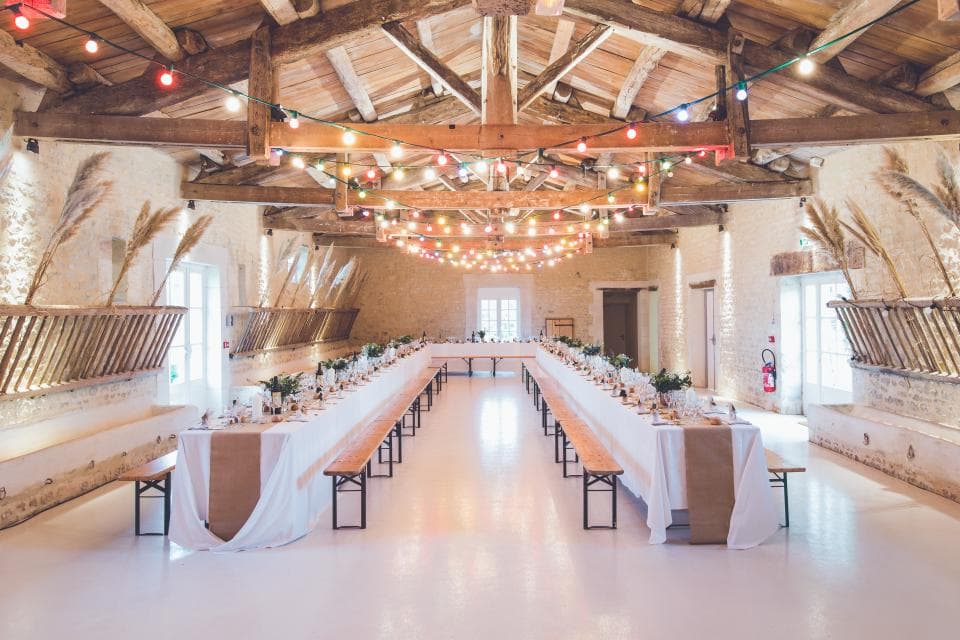 An event hall set with tables and string lights