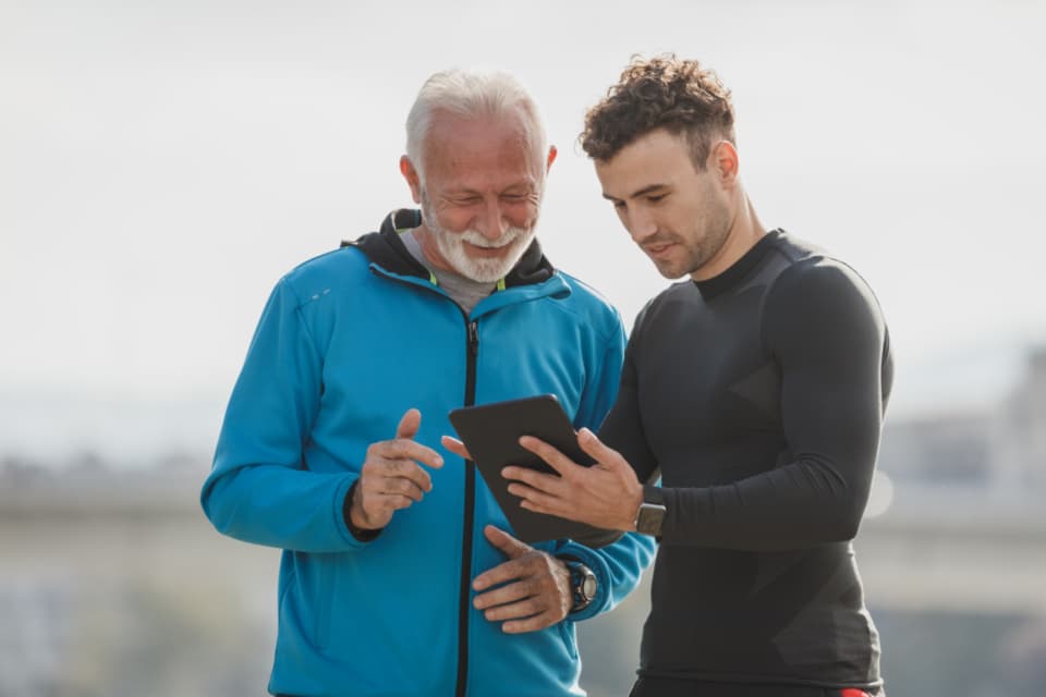 A personal trainer showing a client a plan on a tablet